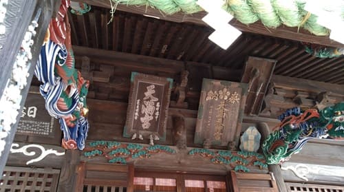 扁額と1本の木材で彫りぬかれた龍の彫刻