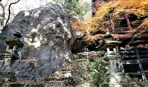 大きな岩の横の崖に建つ岩井堂の風景